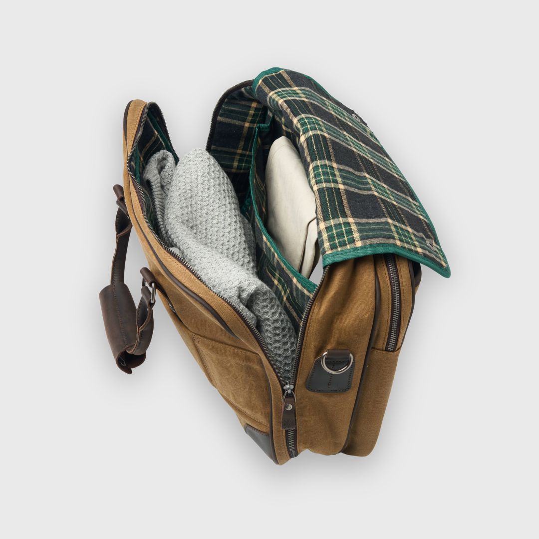 Brown leather bag with plaid lining on a white background