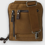 Brown leather bag with zippers and a strap on a white background