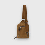 Brown leather sling bag on a light gray background