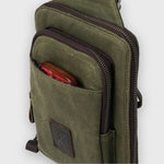 Green canvas crossbody bag with a red item inside on a white background